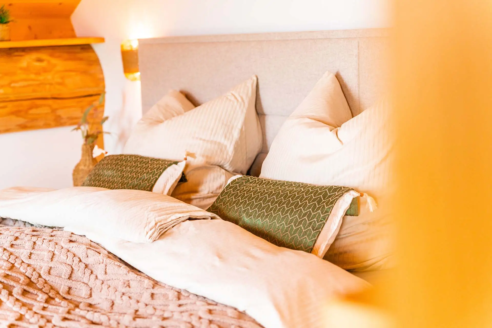 Gemütliches Schlafzimmer mit Zirbenholzbett, hochwertiger Bettwäsche und warmem Licht